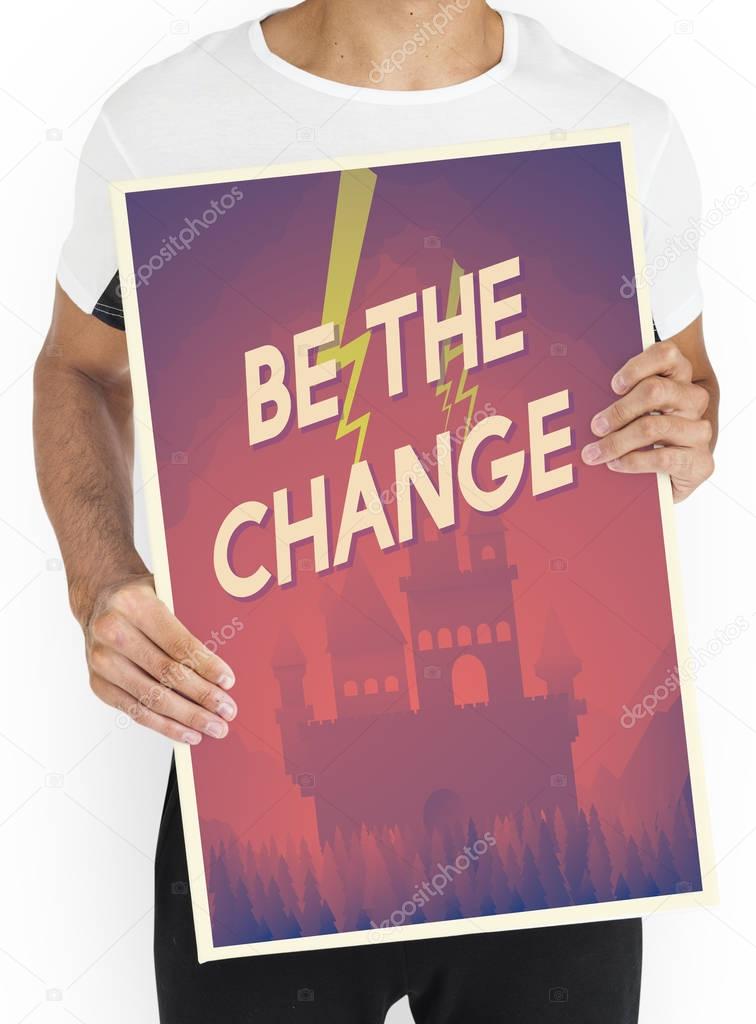 Man in studio holds placard with Bethe Change concept
