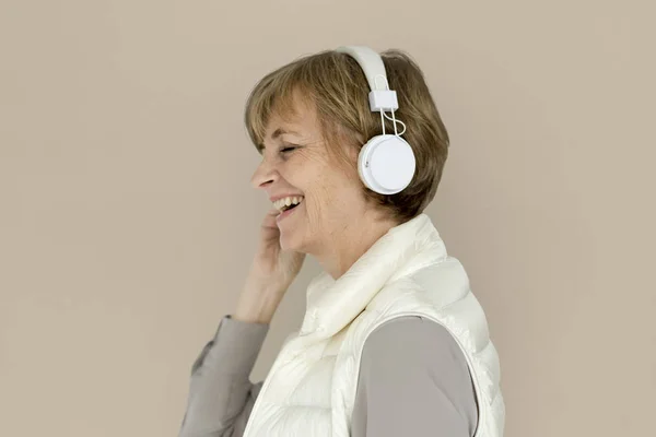 Starsza kobieta ze słuchawkami — Zdjęcie stockowe