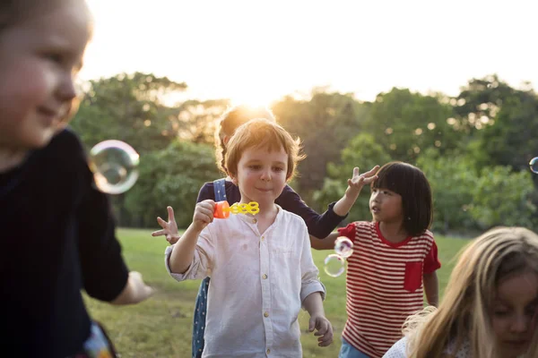 Crianças do jardim de infância jogando bolhas de sopro — Fotografia de Stock