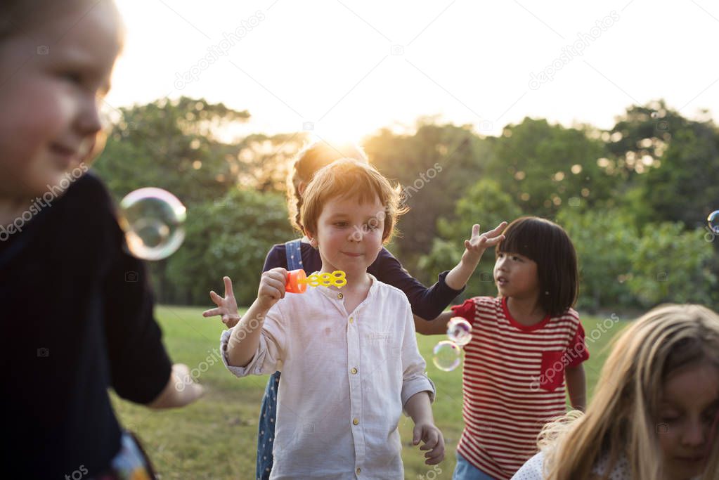 kindergarten kids playing blowing bubbles