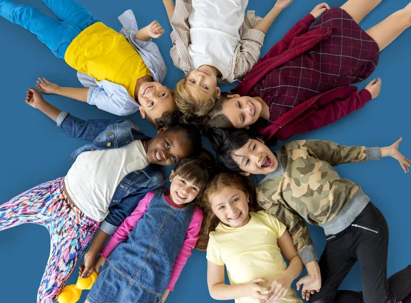 Children lay down together on floor — Stock Photo, Image