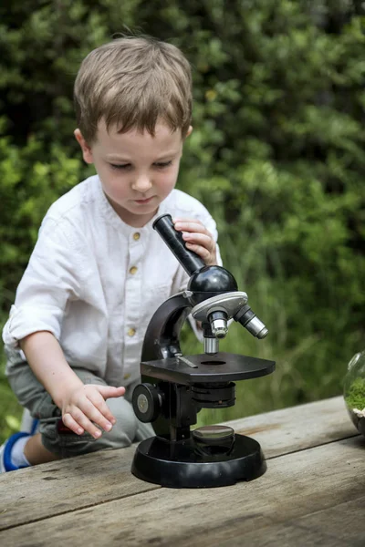Menino brincando com microscópio — Fotografia de Stock