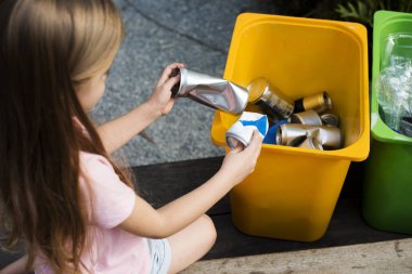 girl throwing cans to trash bin clipart