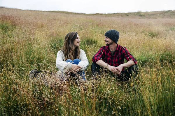 Casal sentado no campo de grama alta — Fotografia de Stock