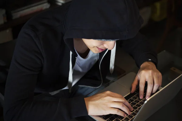 Ragazzo con cappuccio nero utilizzando il computer portatile — Foto Stock