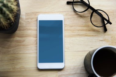 Smartphone, fincan kahve ve gözlük