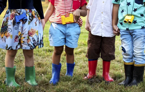 Діти стоять і тримають руки на траві — стокове фото