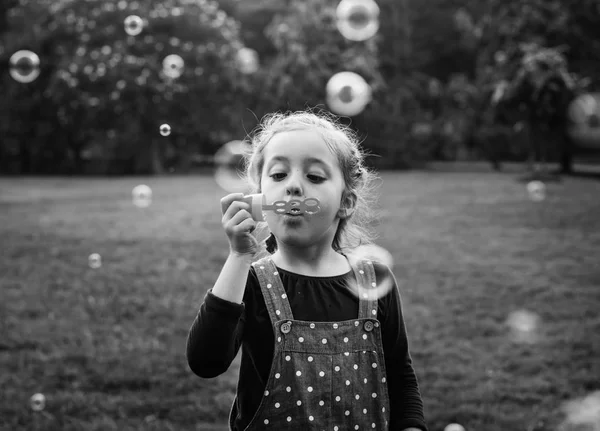 Kid blazen van zeepbellen op aard — Stockfoto