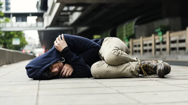 Egy hajléktalan az utcán alszik. — Stock Fotó