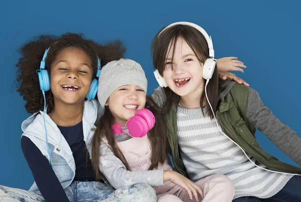 Meninas sorrindo e usando fones de ouvido — Fotografia de Stock