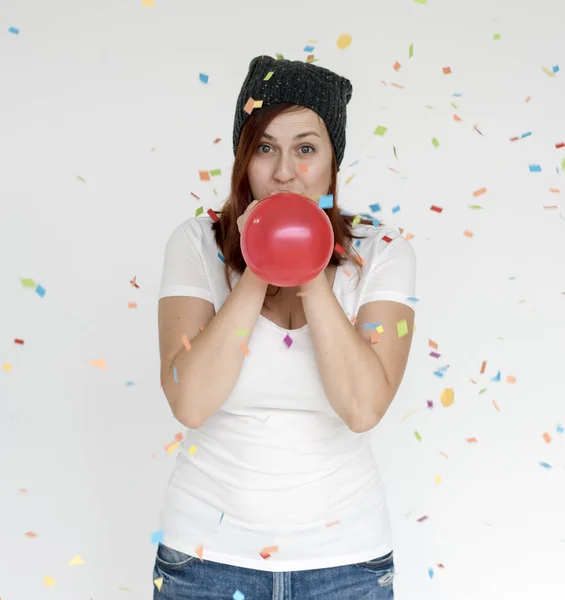 Jovem mulher soprando balão — Fotografia de Stock