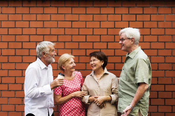 Senioren gemeinsam an Ziegelmauer — Stockfoto