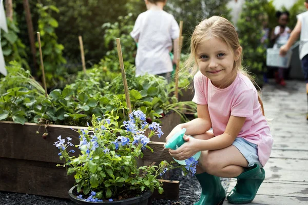 Kid flicka tenderar trädgård — Stockfoto