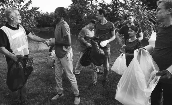 Folk picking up papirkurven i parken - Stock-foto