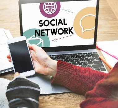 dizüstü bilgisayar önünde Smartphone kullanan kişiler