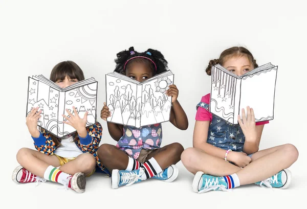 Meninas cobrindo rostos com livros — Fotografia de Stock
