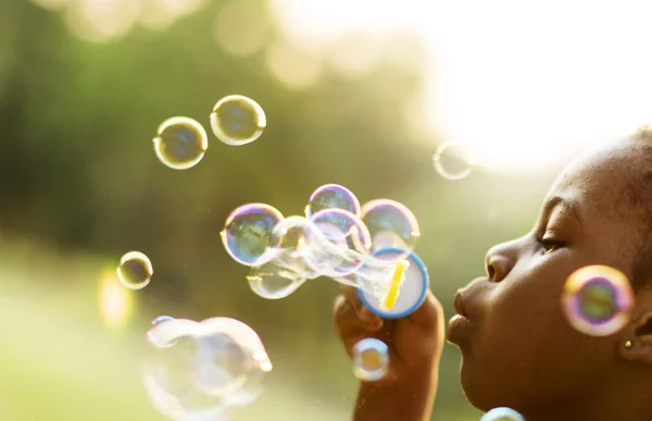 Baby girl blowing bubbles — стоковое фото