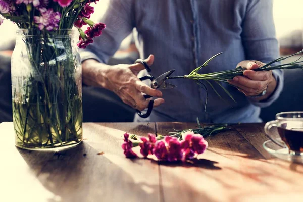 Señora madura arreglando flores — Foto de Stock