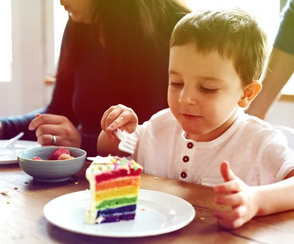 Étkezés a Rainbow torta fiú — Stock Fotó