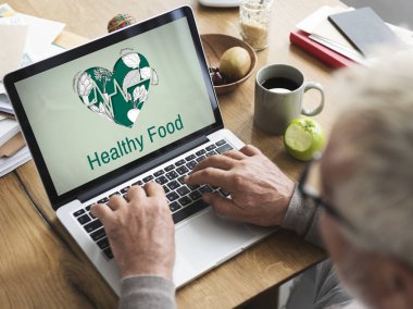 Dizüstü bilgisayarda çalışan kıdemli adam.