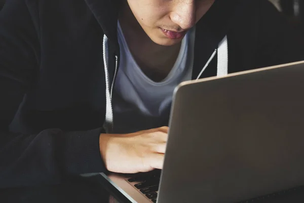 Αγόρι στο μαύρο hoodie χρησιμοποιούν φορητό υπολογιστή — Φωτογραφία Αρχείου