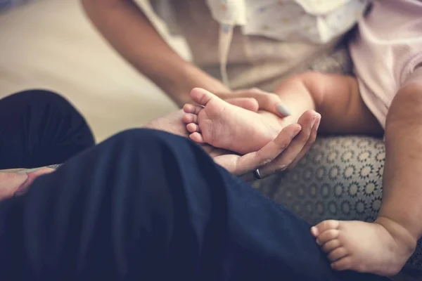 Vater und Mutter halten Fuß des Kindes — Stockfoto