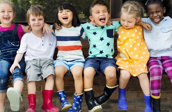 Niños de jardín de infantes sentados y sonriendo — Foto de Stock