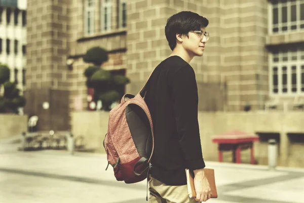 Азіатський студент чоловічої статі, що йде на вулиці — стокове фото