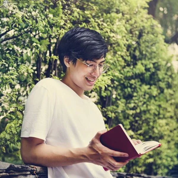 Azjatycki student czytania książki w ogrodzie — Zdjęcie stockowe