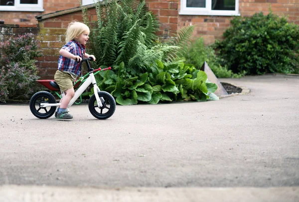 Мальчик катается на велосипеде по асфальтовой дороге — стоковое фото