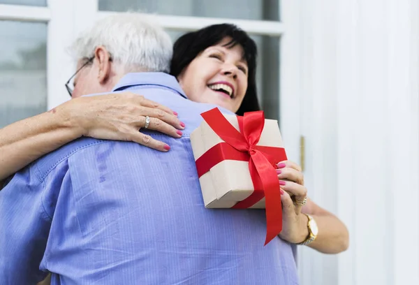 Moglie abbracciare marito per il presente — Foto Stock