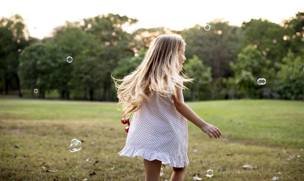Dívka hraje bubliny v parku — Stock fotografie
