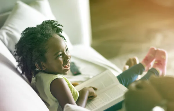 Lächelndes Mädchen mit Buch auf Knien — Stockfoto