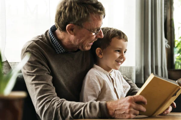 Abuelo y nieto leyendo libro —  Fotos de Stock