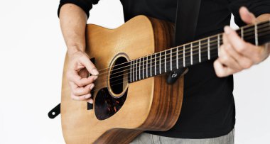 Adam akustik gitar çalıyor.