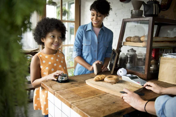 Petite fille africaine avec mère en boulangerie — Photo