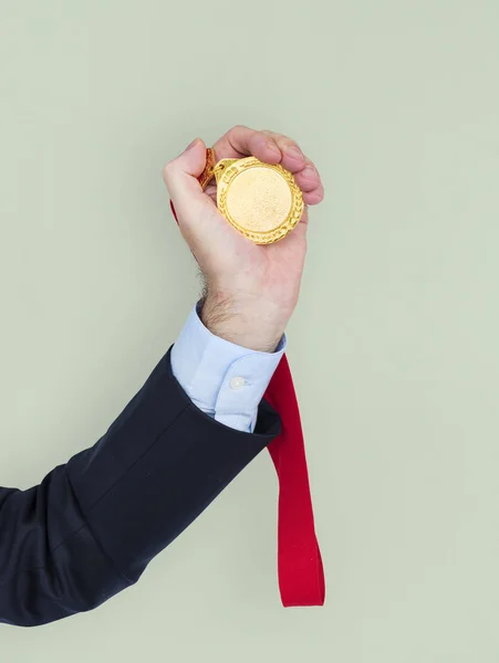 Uomo d'affari in possesso di medaglia in mano — Foto Stock