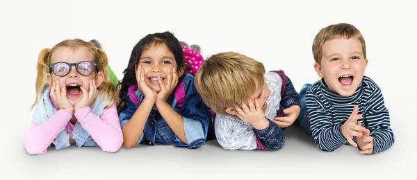 Niños multiétnicos tendidos en el suelo — Foto de Stock