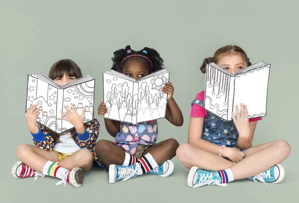 Flickor som täcker ansikten med böcker — Stockfoto