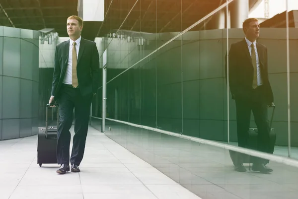 Uomo d'affari in giacca e cravatta a piedi con bagagli — Foto Stock