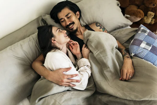 Par är på säng kramas — Stockfoto