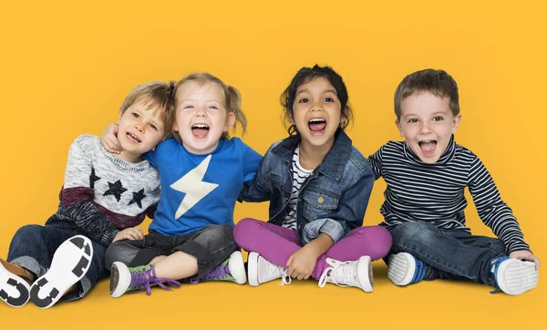 Niños felices sentados en el suelo —  Fotos de Stock