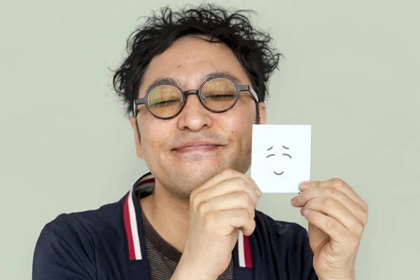 Muž, který držel papír s usmívající se obličej — Stock fotografie