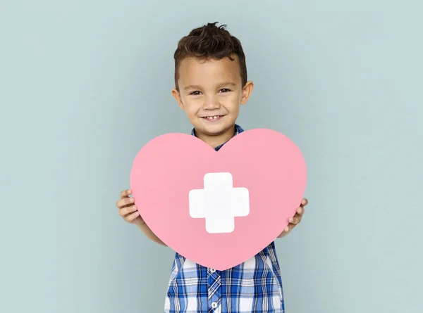 Niño sosteniendo el corazón con cruz — Foto de Stock