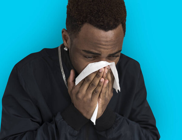 Man sneezing into paper Tissue