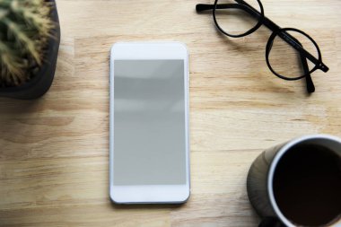 Smartphone, fincan kahve ve gözlük