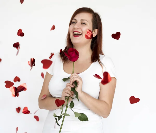 Mujer joven sosteniendo rosa roja — Foto de Stock