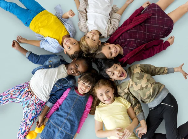 Children lay down together on floor — Stock Photo, Image