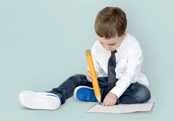 Jongen met grote potlood schrijven — Stockfoto