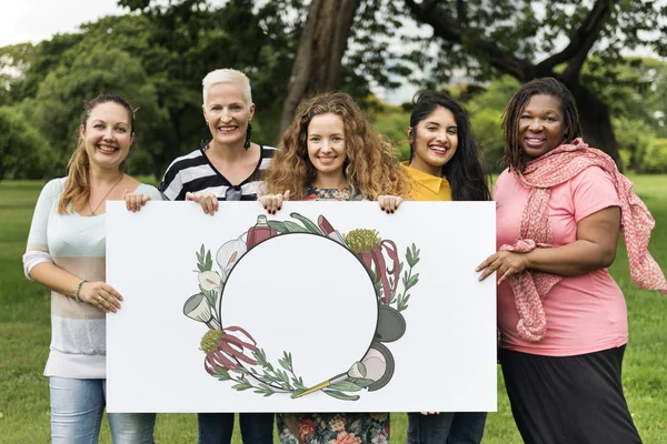 Cinco mujeres sonrientes sosteniendo pancarta — Foto de Stock